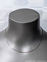 Front view of the sterling silver necklace on a display bust under natural light.