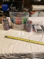 Wide shot showing three main pen containers and a pack of black fine liners.