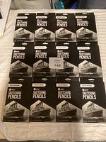 12 packs of Pencil Buddies artist sketching pencils, front view showing packaging and branding