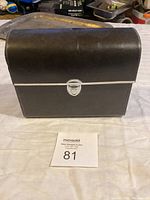 Closed view of black carrying case for binoculars with silver latch.