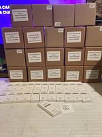 Stack of brown case boxes and row of white retail boxes on table