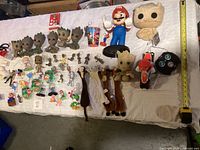 Full view of all collectibles including Baby Groot figures, Super Mario figure, small figurines, and remote control motorcycle toy