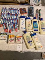 Photo showing all personal hygiene items: toothpaste tubes, lotion bottles, soap bars, razors, and toothbrush