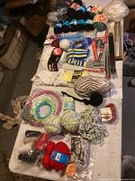Top-down view showing full lot including yarn, knitting looms, needles and partially knitted pieces arranged on a table.