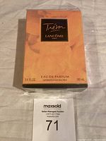 Front view of the unopened and sealed box of Lancôme Trésor Eau de Parfum in peach colored packaging with black label and gold accents.