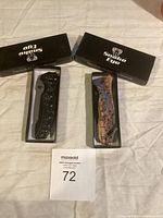 Two boxed folding knives from Snake Eye, one black skull embossed, other zebras graphic