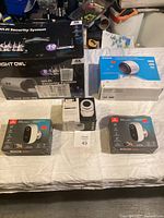 Overview photo of security system box and multiple security cameras in their retail boxes on a table.