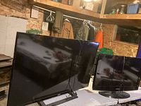 Two RCA TVs, 32 inch and 50 inch, standing side by side, black frames, no remotes.