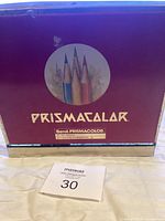 Metal tin closed showing Prismacolor logo and pencil illustration on lid.