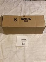 Cardboard box with Yamaha FC4 label, shown folded flat on a surface.