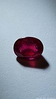 Top view of oval cut natural ruby showing rich blood red color and facets.