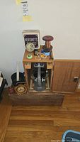 Microscope in wood case with accessories on top and Telechron clock in front