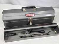 Open toolbox showing removable tray containing assorted tools and electrical supplies.