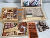 Photo showing three wooden boxes filled with assorted rubber stamps and the Friskars stamp alignment tray set.
