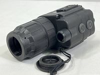 Side view showing textured focus ring and detached lens cap attached by string.