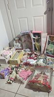 Overview of the entire collection showing boxed and unboxed dolls on tile floor near door