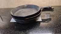 Stacked view of 3 cast iron pans showing handles and overall size