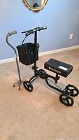 Photo showing Elenker knee scooter with black basket, three wheels, padded knee rest, and handlebar brakes.