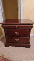 Front view of Ashley Furniture nightstand showing two drawers and brass pulls