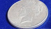 Front and side views of the 1922 Morgan Silver Dollar coin showing date, inscriptions, and rim details.