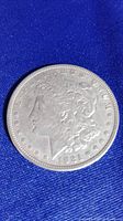 Front (obverse) side of 1921 Morgan silver dollar coin showing Lady Liberty, inscriptions, and the year 1921 with visible details.
