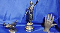 Photo showing moose head, Lady Justice statue, and cast iron hand on blue fabric background.