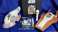 Photo showing two Star Wars ships, Hot Wheels Quick D-O vehicle in packaging, Stormtrooper Pez dispenser, and Star Wars fine art 1000-piece puzzle box