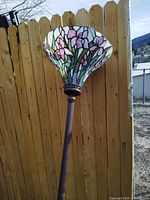 Full view of Tiffany style stained glass lamp shade showing colorful pink, purple, and green floral design.