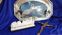 Photo showing the framed 3D religious artwork, brass crucifix, and The Last Supper sculpture