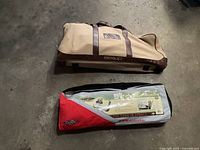 Two fabric carrying bags for croquet and badminton sets on a concrete floor