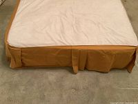 Full view of full size bed skirt on bed, showing front pleated edge and fabric color.