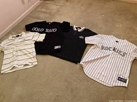 Four Colorado Rockies themed shirts including two white pinstriped jerseys, a black polo, and a black t-shirt with 'COLORADO' text