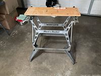 Front view of Black & Decker Workmate portable worktable standing opened on concrete floor.