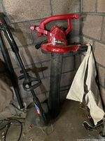 Red Toro leaf blower leaning against wall