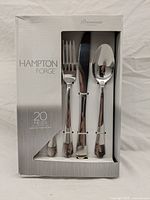 Front view of the boxed 20 piece cutlery set by Hampton Forge, showing fork, knife, and spoon through window on front packaging.
