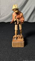 Front view of the ANRI Pied Piper figurine showing detailed carving and natural wood on black background.