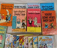 Photo showing seven Andy Capp comic books with colorful covers featuring cartoon characters and titles.