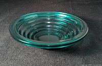 Side angle view of the cobalt blue glass bowl showing the stepped concentric ring design inside the bowl and the thickness of the glass.