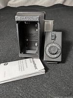 Supra black keysafe lockbox enclosure open showing inside and Access Point combination dial lock alongside instruction manual.