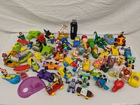 Full collection of vintage McDonald's promotional toys laid out on white fabric.