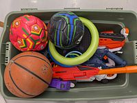 Top view showing balls, frisbees, and some Nerf blasters in a plastic bin