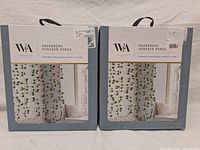 Two unopened blue boxes containing W&A Cascading Curtain Vines with window showing product inside.