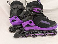 Side view of PAPASION inline skate showing black and purple colors, buckle closure, adjustable frame, four wheels, and heel brake.