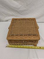 Closed rectangular wicker sewing basket showing woven texture and size measurement tape indicating 11.75 inches width.
