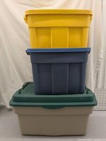 Photo shows the three stacked storage totes; yellow on top, blue middle, white with green lid bottom.