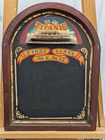 Front view of wooden framed chalkboard with painted Titanic theme and empty menu area.