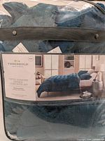 Comforter set in packaging with label showing the product on a bed, branding, and king size specification.