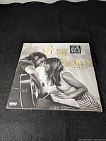 Front cover of the sealed vinyl soundtrack showing Bradley Cooper with guitar and Lady Gaga leaning close, title in gold, shrink wrap with sticker