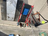 Overview of all items including the heavy-duty creeper, homemade creeper platform, folding shopping cart, 4 Wheel Wonder dolly, jack stands, and hydraulic jacks, displayed on the ground.