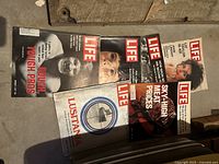 Five Life magazine covers laid out on floor showing varied cover images including a football player and Lusitania ship.